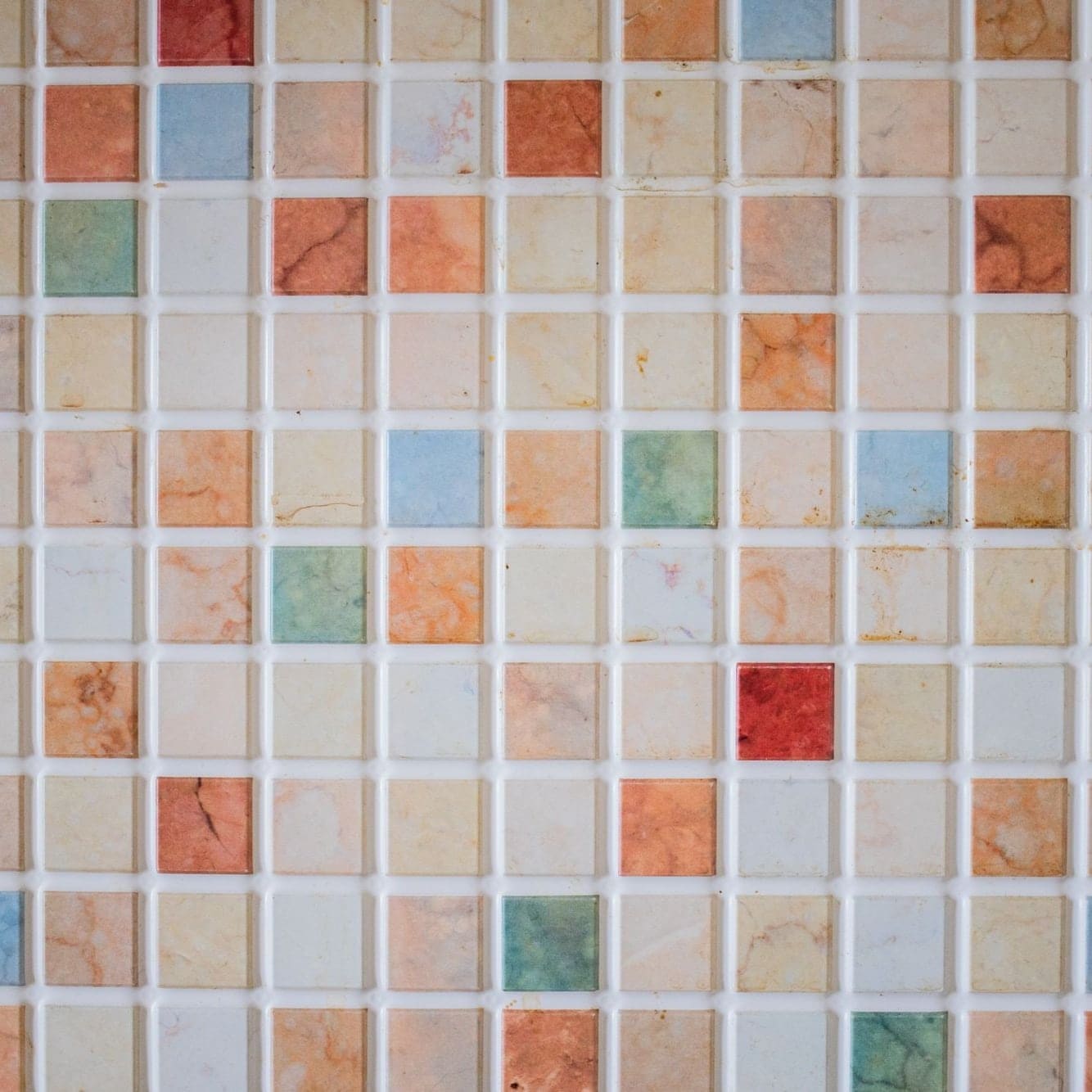 Mosaïque de petits carreaux de pierre aux tons variés, joints blancs réguliers